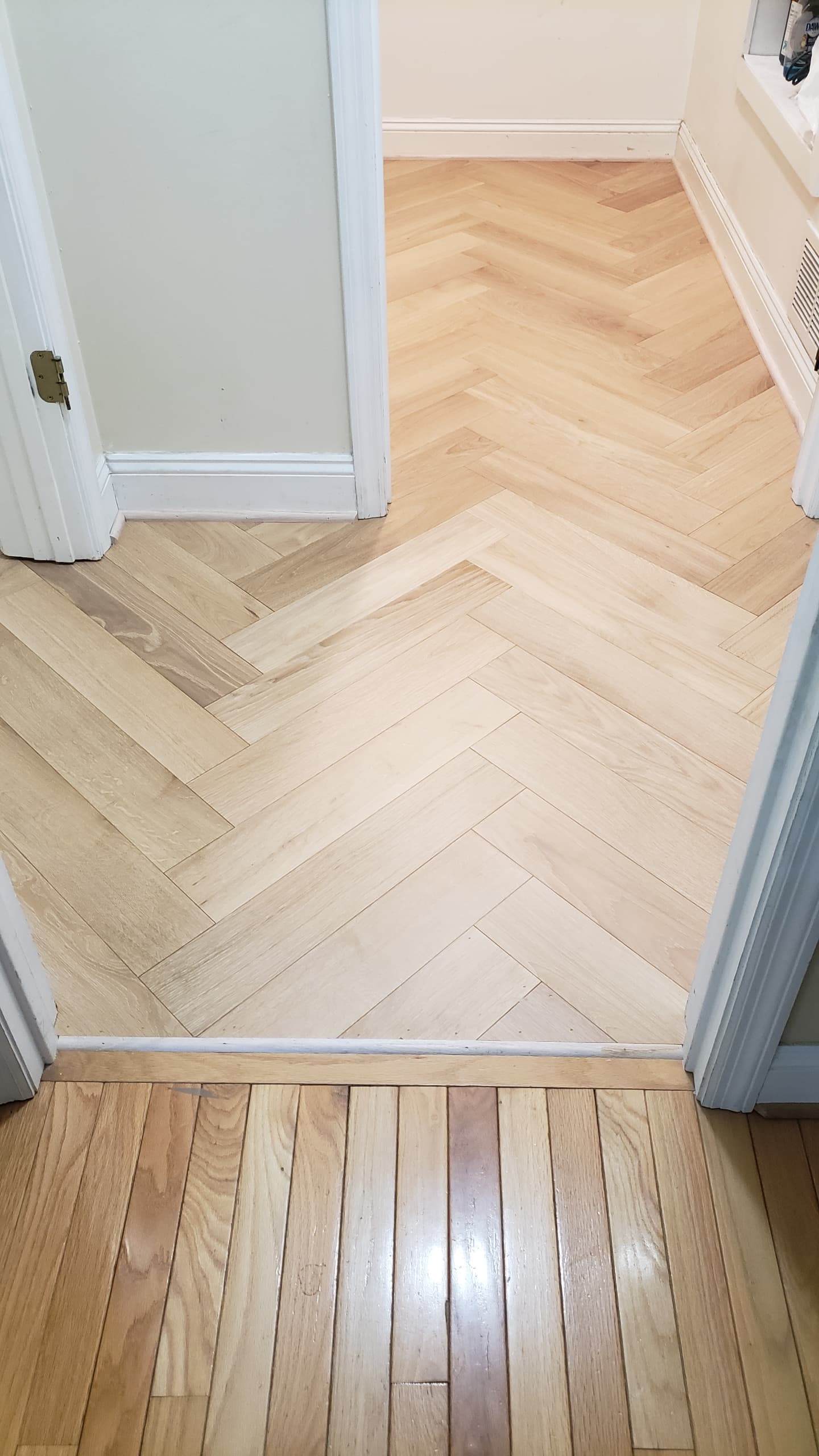 Herringbone oak flooring through doorway by Ventura Home Improvement